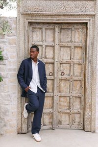 Navy linen set against carved wooden doors and stone