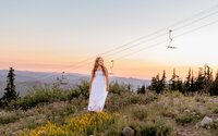 Sandy, Oregon high school senior walking through fields of wildflowers at timberline lodge on mount hood with the ski lift in the background.