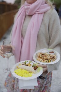 Wedding guest holds a plate of food from Millie's Food Truck. Nantucket welcome party.