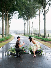 A joyful, real moment of a proposal along a tree-lined estate driveway, captured with a documentary style that preserves the authentic emotion of the day.