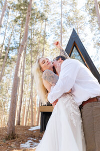 During their elopement, the couple dips in front of their A-frame cabin venue.