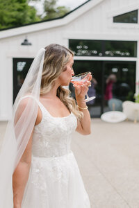 bride sipping champagne during wedding cocktail hour