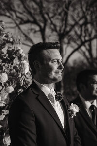 a groom sheds a tear watching the bride walk down the iasle at their castle wedding