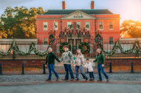 Family walking together in front of Tryon Palace during a New Bern family photo session