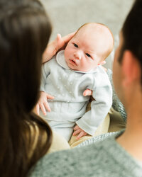 Newborn baby looking up at parents during a candid in-home lifestyle newborn photography session.