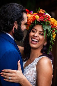 Bride smiling into the camera as husband holds