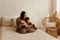 a mother cuddles her babies during her newborn session in mckinney,texas.
