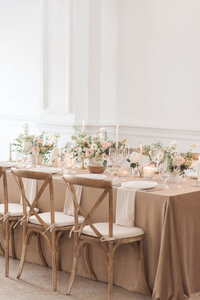 Wedding reception decor with candles, floral arrangements, and wooden chairs in wedding photography Detroit MI