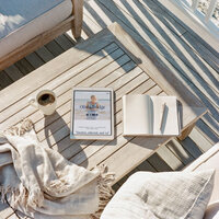 iPad mockup of the Coastal Dream one-page website template resting on a wooden outdoor table