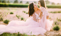 A mom and her young daughter sit in a Merton field wearing matching gowns which their portrait is taken by Kara Reese.