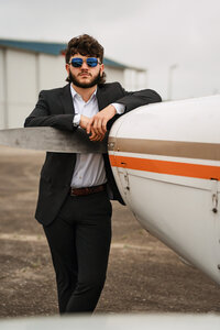 Senior portrait at a small hangar near Mobile International Airport in Mobile, Alabama — posing near airplane