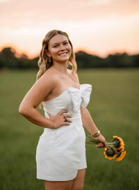 Senior girl posing with a bouquet of sunflowers at Loblolly Farm in Semmes, Alabama.
