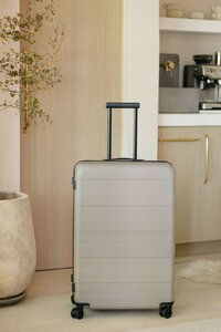 Large MUJI suitcase photographed in a naturally lit kitchen interior