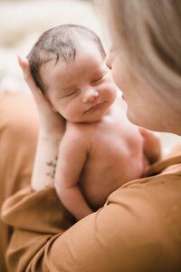 moeder en newborn knuffelen