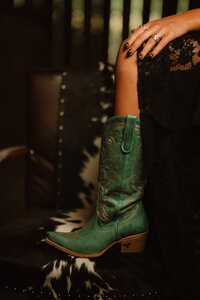 Senior portrait at Triple T Farms in Fruitdale, Alabama — close-up of teal cowboy boots and her
class ring.