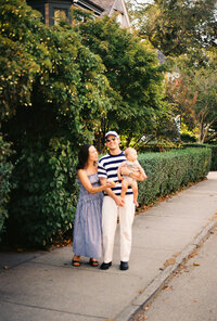 Family smiling for a family portrait on the streets of Brooklyn, New York