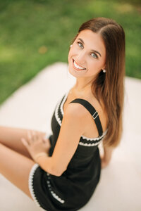 Senior portrait in downtown Foley, Alabama — top-down headshot sitting on steps, looking up at
the camera.