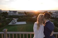 Bride and Groom lookout to ocean from rooftop.
