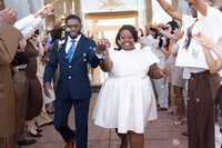 Bride and groom exiting joyfully together as guests cheer during their wedding recessional