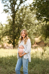 a mother embraces her belly during her maternity session in west texas captured by shelly voss