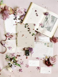 styled flat lay with florals, textures, and soft romantic wedding elements in pastel tones