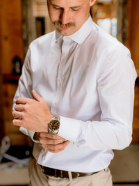 Groom detail portraits getting ready at Brightwater weddings and events in Oregon City,fastening his watch.