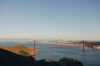 Golden Gate Bridge with San Francisco skyline in the background during daytime, perfect for a destination wedding photographer.