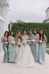 Bride surrounded by bridesmaids in teal dresses at Belle Mer Newport.