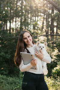 Spontane branding foto van fotografe met laptop en hondje in haar armen