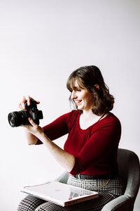 Morgan Wright, photographer and creative director of Mewphotovideo, reviewing her camera during the creative process.