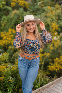 A student from Catholic Memorial High School poses for her senior portraits on the boardwalk in Waukesha's Retzer Nature Center.