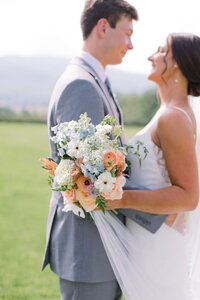 Close-up of bridal bouquet with peach roses, blue delphinium, and Queen Anne's Lace by Flowergirl Cville at King Family Vineyard, Crozet VA | Photo by Paige Ryan Photography