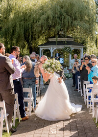 Bride and Groom kissing in the middle of the isle in the Abigail Gardens at the Abernethy Center in Oregon City.