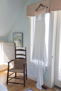 Dress hangs in window of nantucket cottage. Deborah Zoe Photography.