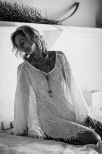 Boudoir experience in studio model seated on bed