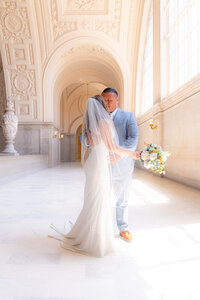bride and groom posing at san francisco city hall wedding