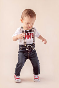 one year old boy walking and smiling during milestone photography session