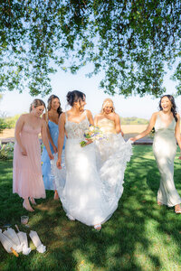 pastel bridesmaids candid with bride under willow tree at rainbow oaks ranch in sanger california