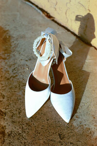 bridal shoes with pearls and heels sitting outside in the sunlight