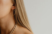 kaboompics_Beautiful woman with gold jewelry - unrecognizable female wearing chain necklace and earrings