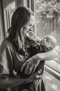 A black and white picture of a mom holding her infant son
