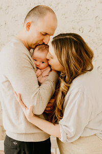 parents hugging infant in middle