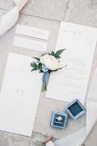 wedding-rings-boutonniere-candles-lie-marble-tiles-top-view