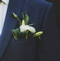 Groom in a blue suit with pinned flower