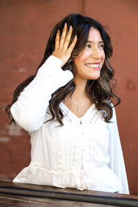 Close-up portrait of a smiling high school senior girl in a white blouse, Yucaipa senior photos by Kaitlyn Dawn Photography.