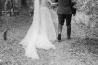 black and white image of bride and groom walking away at mackinac island