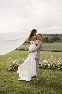 Groom sweeping bride off her feet. Florals by Flowergirl Cville. Photography by Brittany Stark Studios.