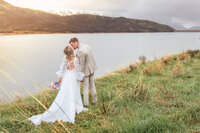 bride and groom kissing in front of water in Detroit