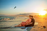 Expectant parents relaxing at sunset during a beach maternity session in Atlantic Beach North Carolina