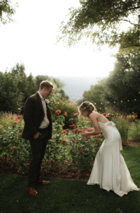 A bride and groom at their garden wedding smelling flowers during their portraits in NYC. Parr Photo Co New York wedding photographer